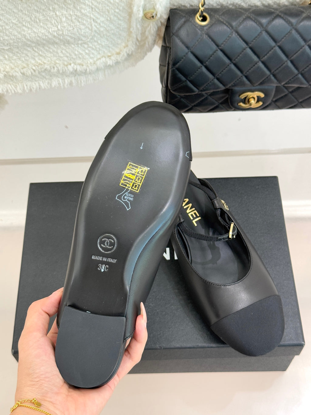 Dark flat shoe sole with gold CHANEL stamp, heel side view