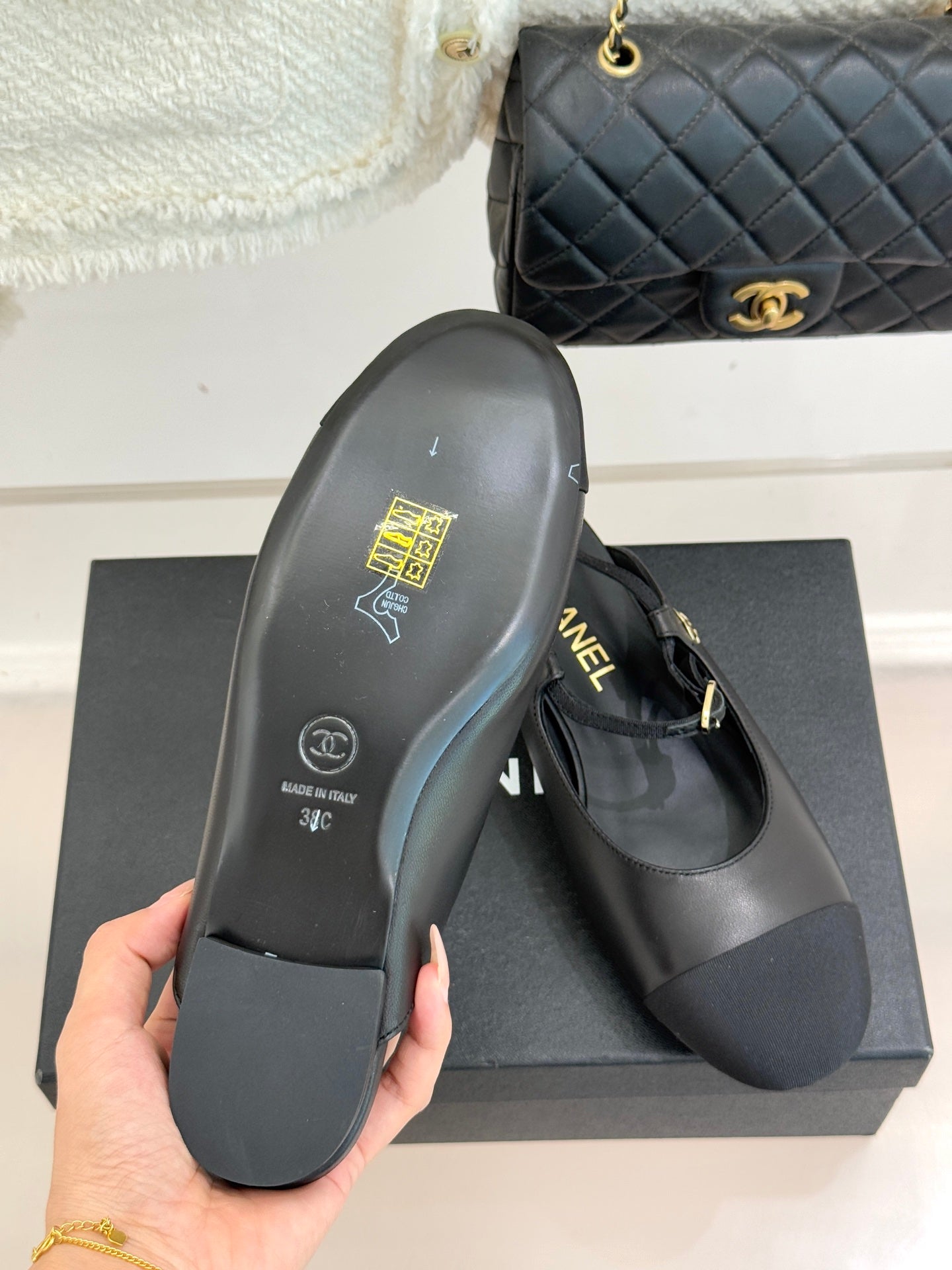 Dark flat shoe sole with gold CHANEL stamp, heel side view