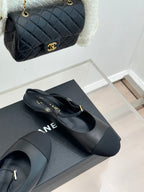Dark slingback flats with gold buckle, resting on a shoe box