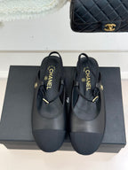 Dark CHANEL slingback flats with gold buckle and woven logo tab, front view