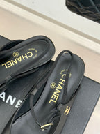 Dark slingback flats with gold buckle and CHANEL text on the insole