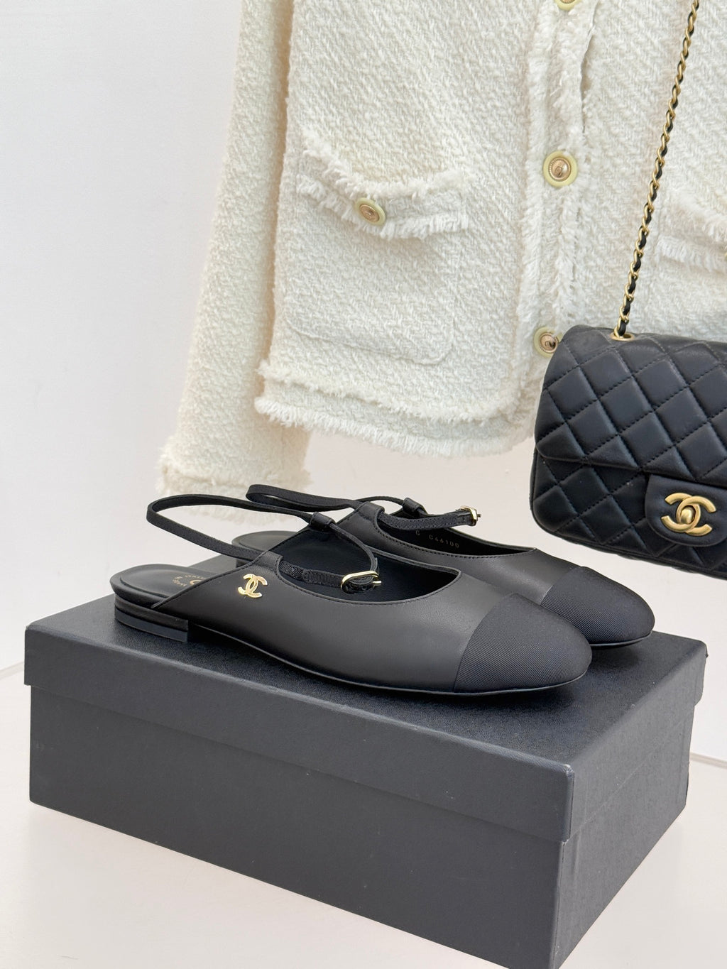Black slingback flats with gold logo buckle and pointed toe