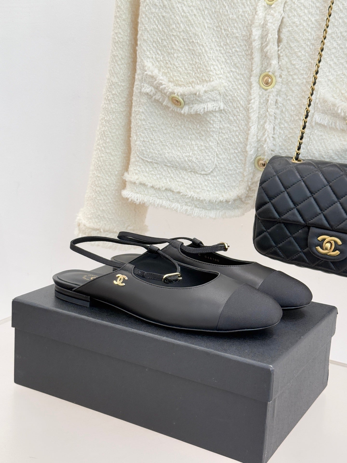 Black slingback flats with gold logo buckle and pointed toe