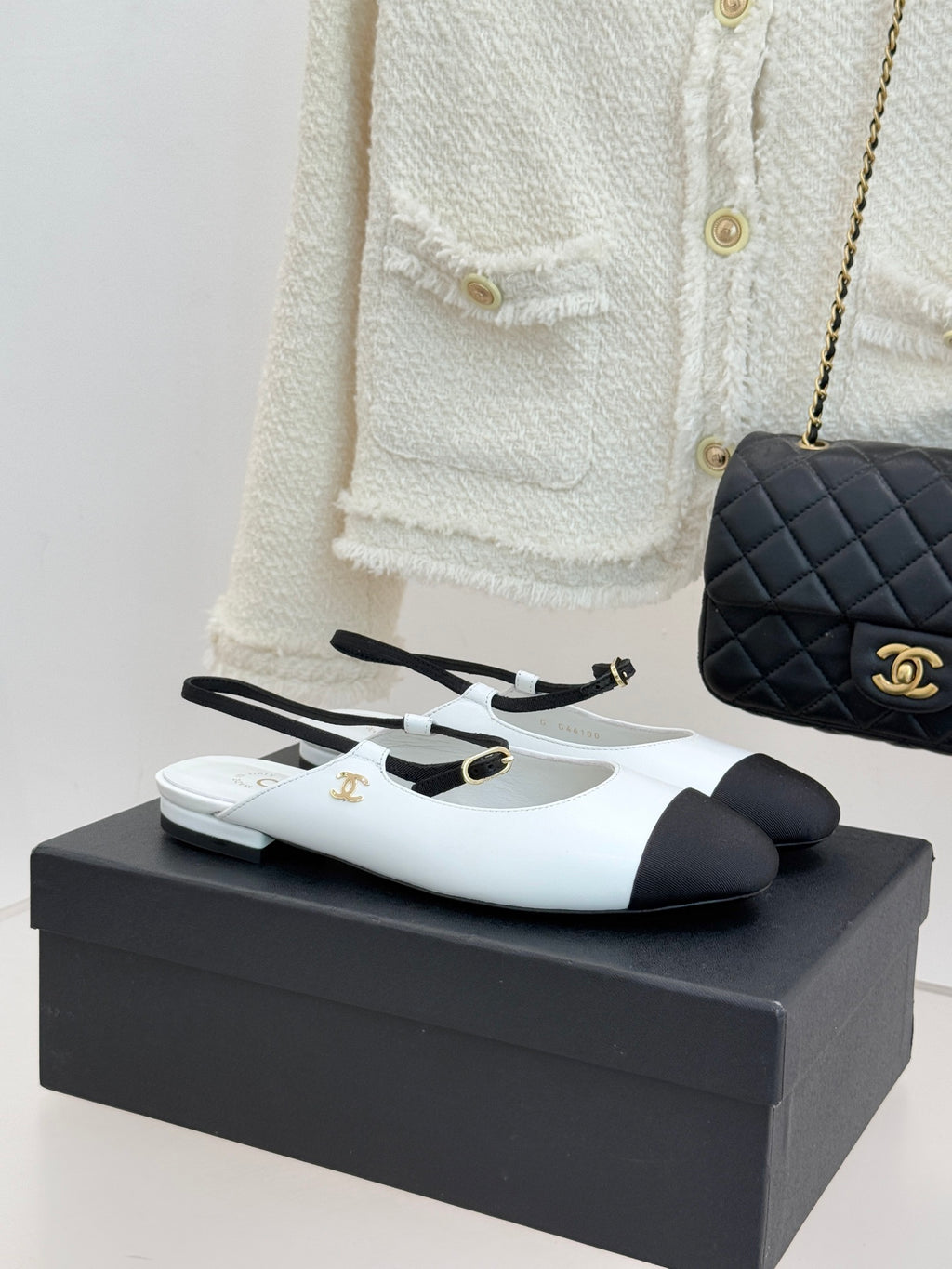 White and black two-tone Chanel flats with gold-tone buckle detail