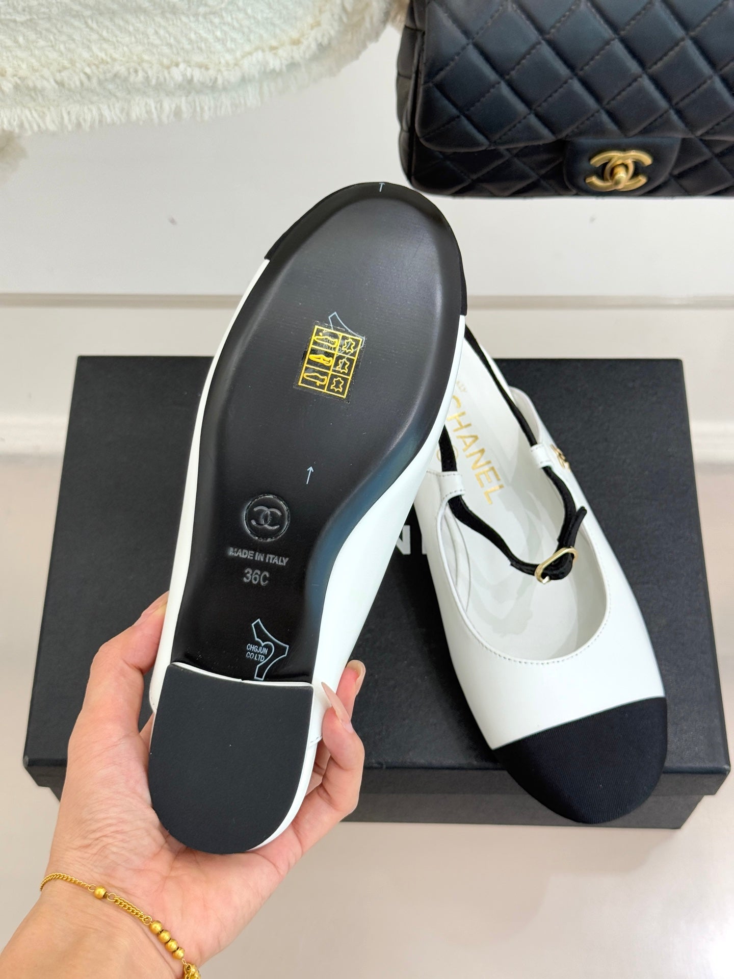 Chanel flat outsole view with black rubber base and white upper trim