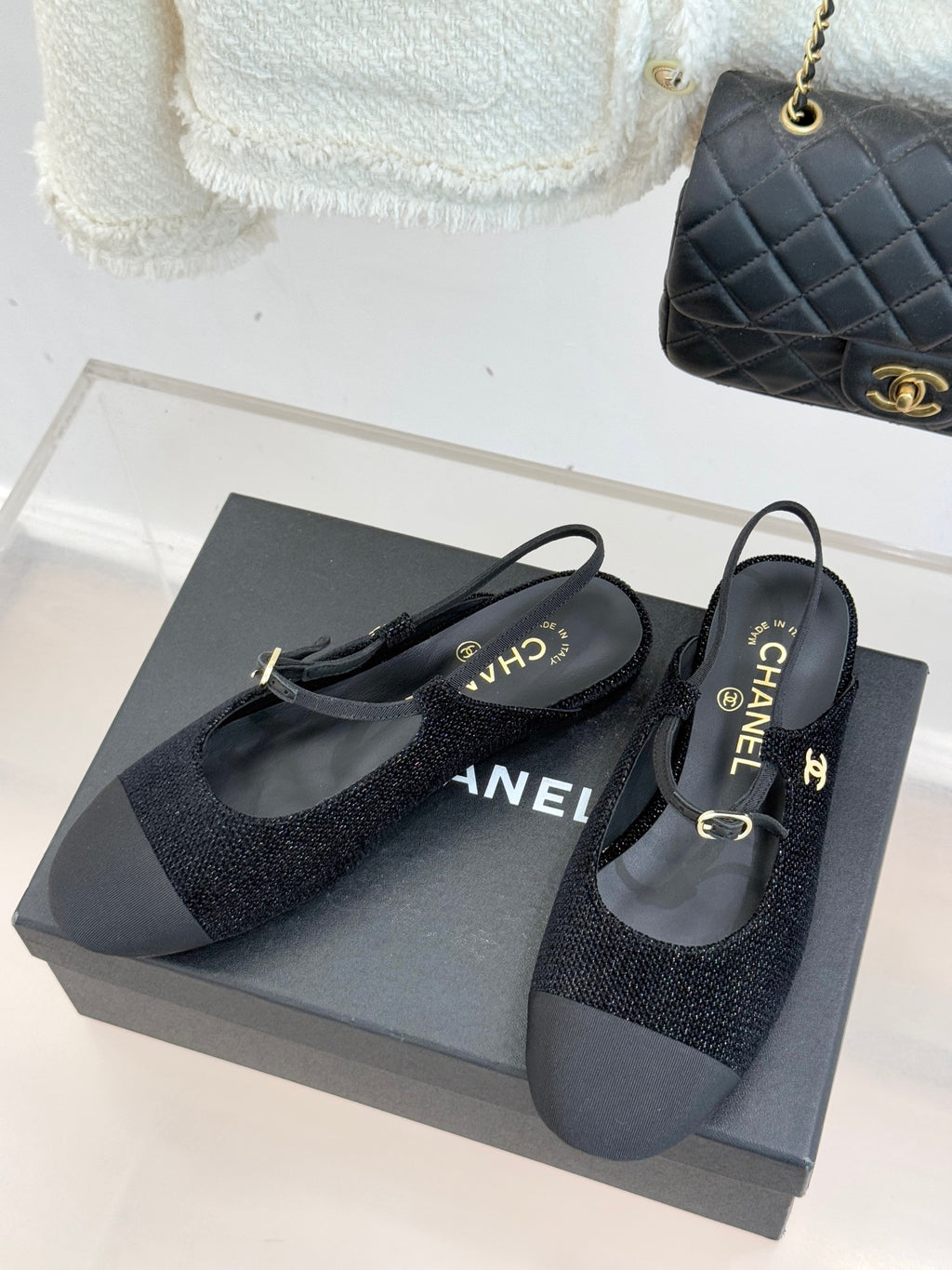 Chanel ladies black slingback flats on grey box; gold CC emblem and buckle