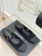 Chanel ladies black slingback flats pair with gold CC accents and engraved heel label