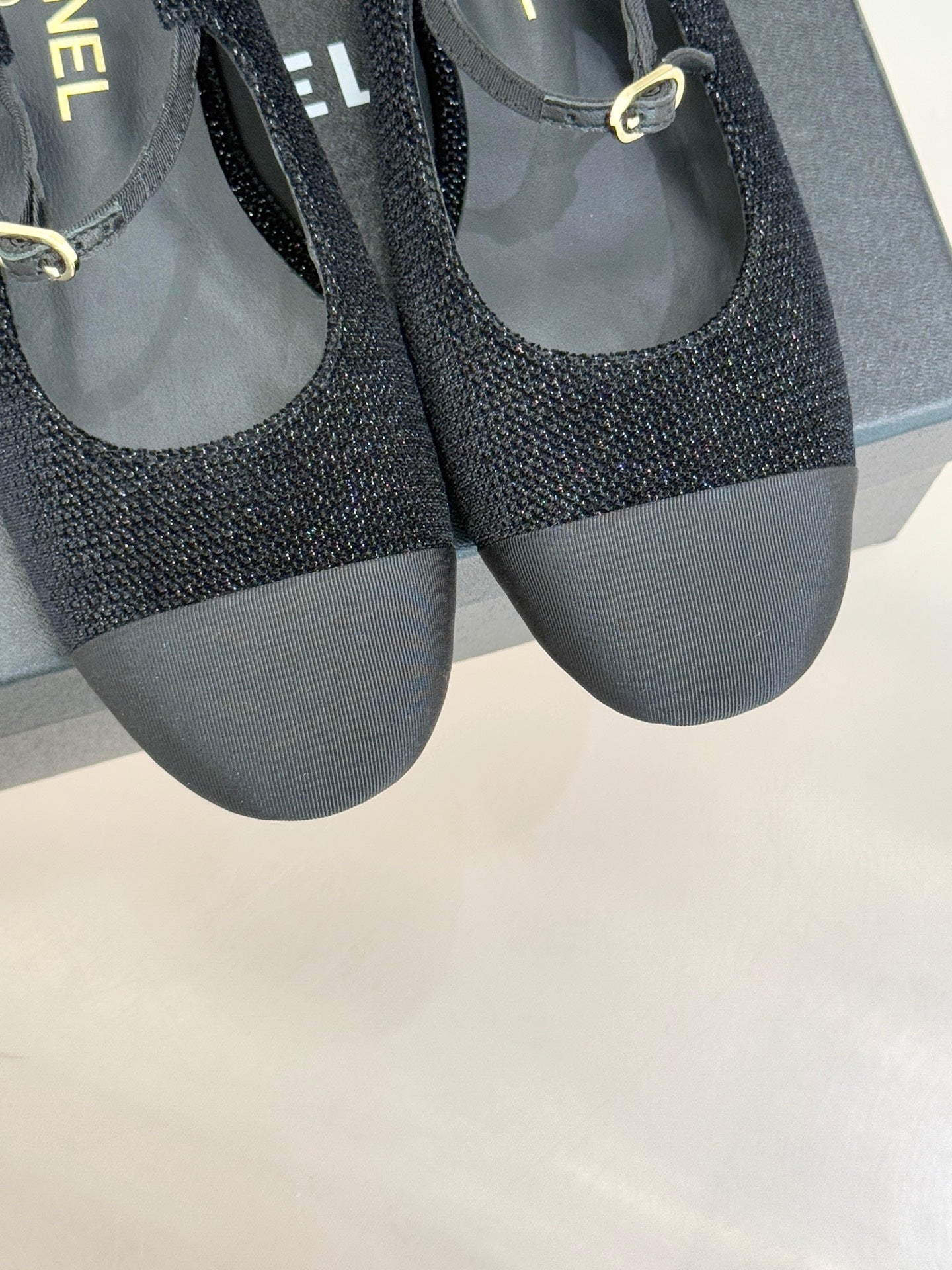 Chanel ladies black slingback flats close front view with gold CC charm near strap