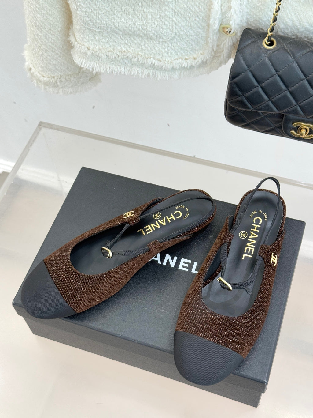 Chanel flats in brown textured fabric with dark navy soles, gold CC charm detail