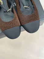 Chanel flats close-up, brown textured uppers with navy soles and gold metal detail