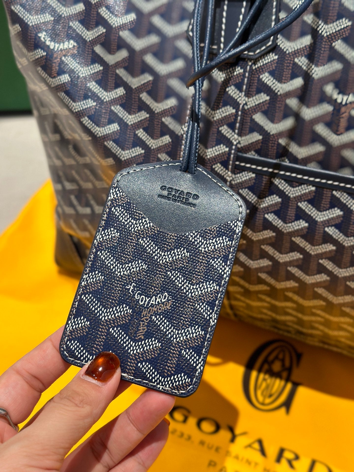 Goyard duffel bag leather side label on dark blue monogram canvas.