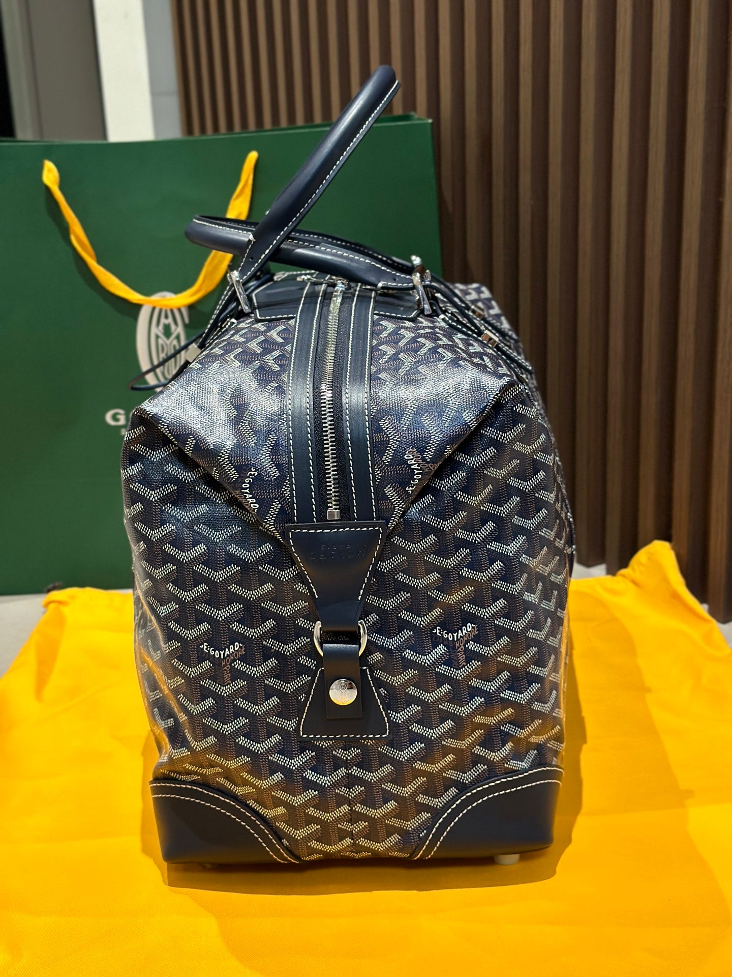 Goyard duffel bag back view, dark blue monogram canvas, zip seam and metal feet.
