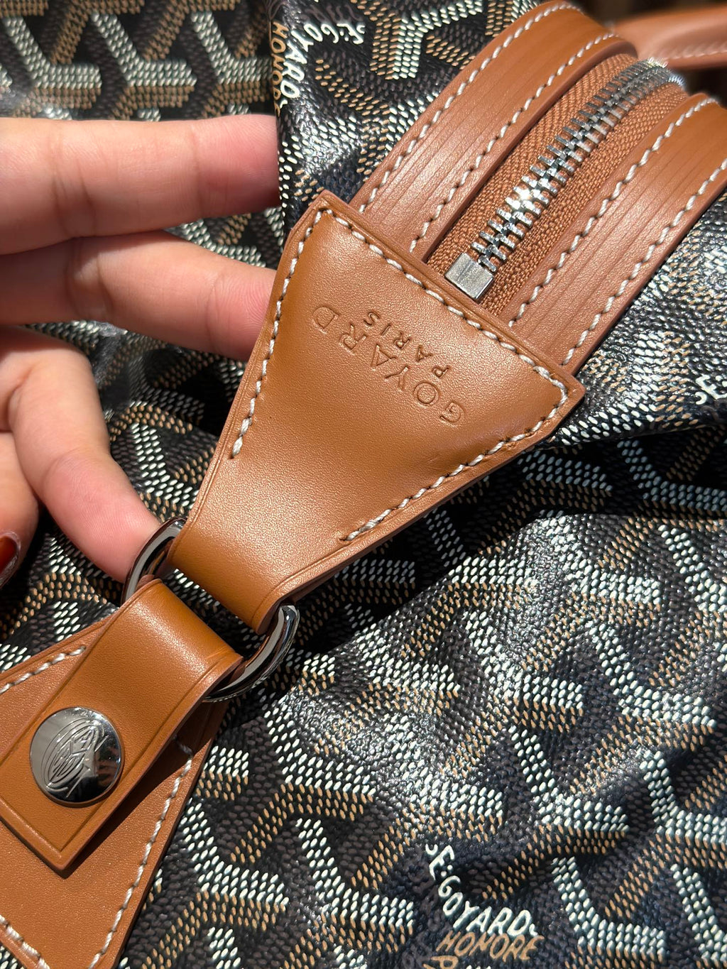 Goyard leather patch and stitching on bag strap with textured Goyardine pattern