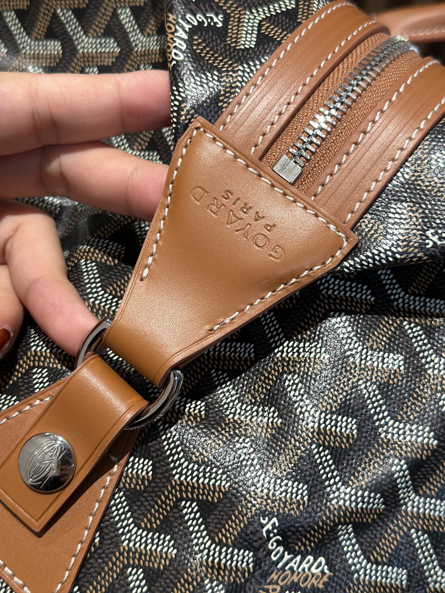Goyard leather patch and stitching on bag strap with textured Goyardine pattern