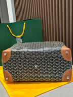 Goyard bag back view with tan leather corner tabs and top handles, zip-top closure