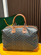 Goyard bag with gray Goyardine pattern, tan handles, and structured zip-top shape