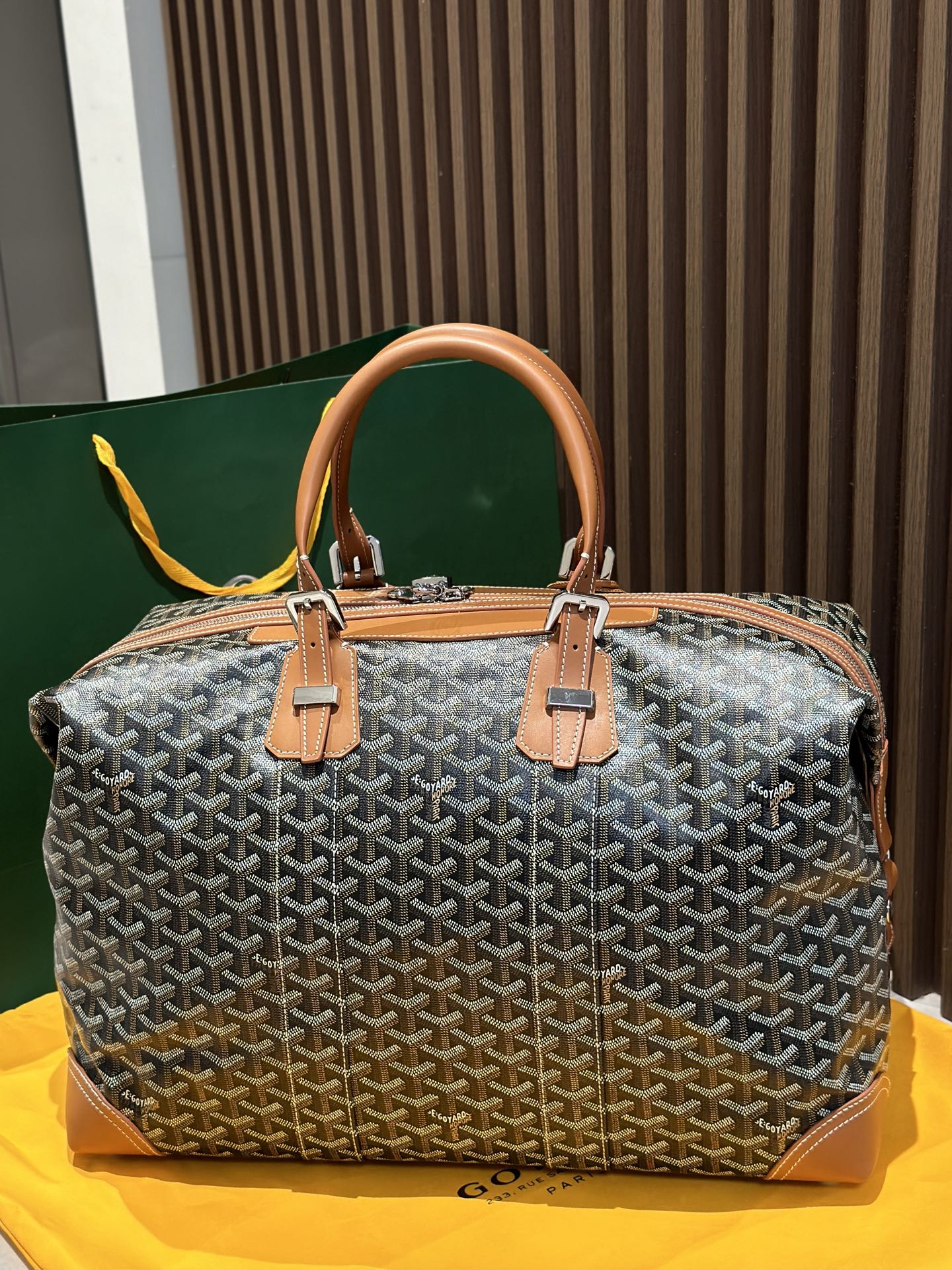 Goyard bag with gray Goyardine pattern, tan handles, and structured zip-top shape