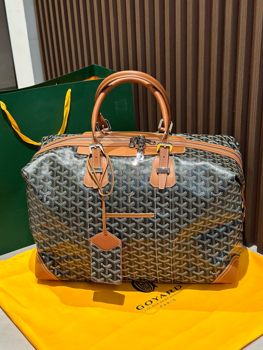 Goyard bag with gray patterned Goyardine and tan leather handles, top zipper