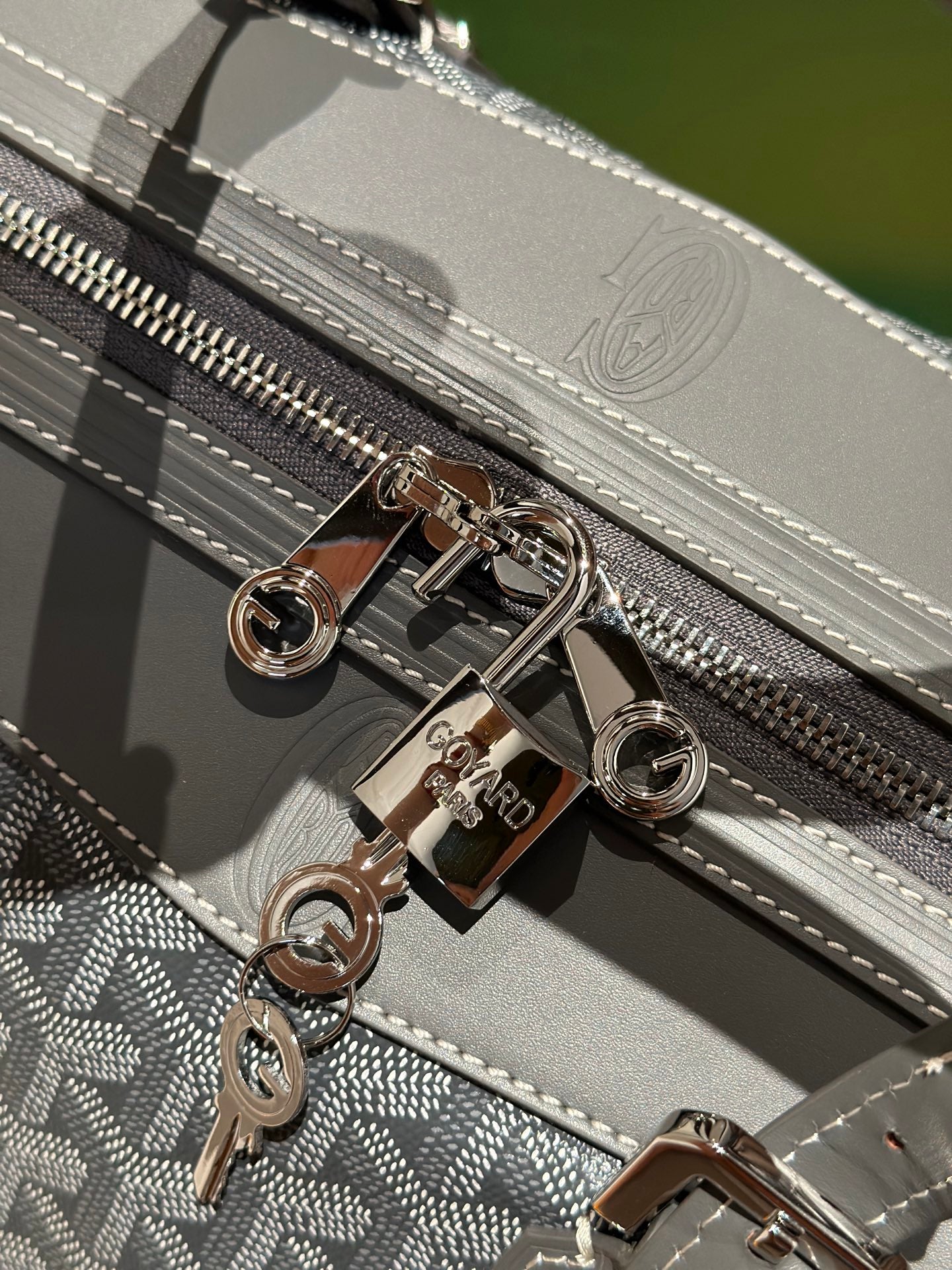 Goyard duffel bag zipper with silver hardware and patterned trim detail