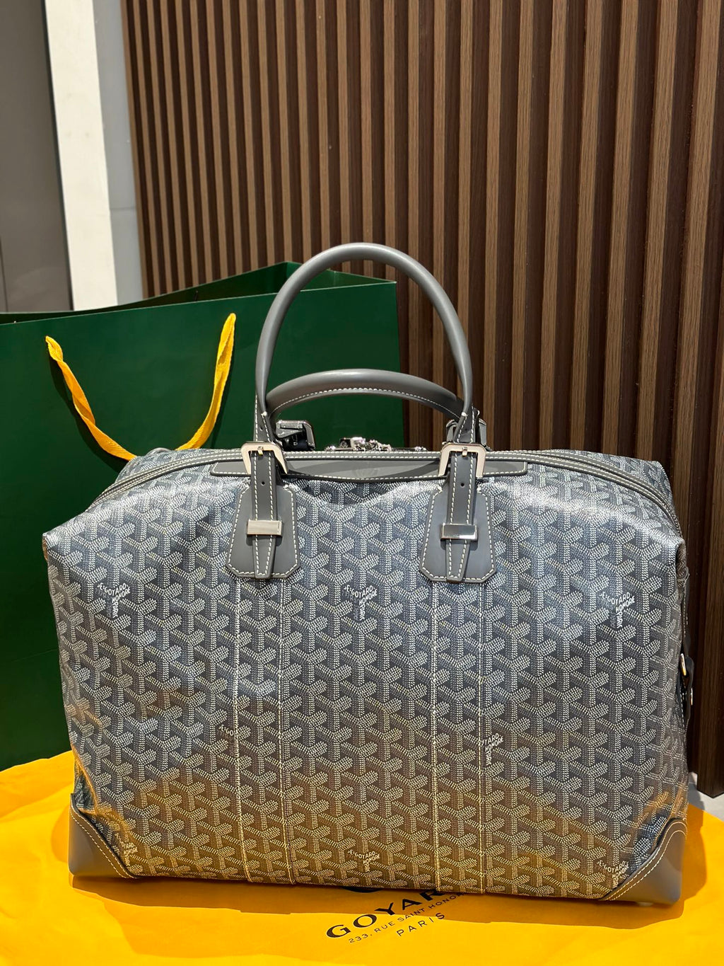 Goyard patterned duffel bag in light gray with dual handles and front clasp hardware