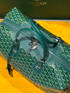 Green patterned duffel bag with dual top handles and silver hardware