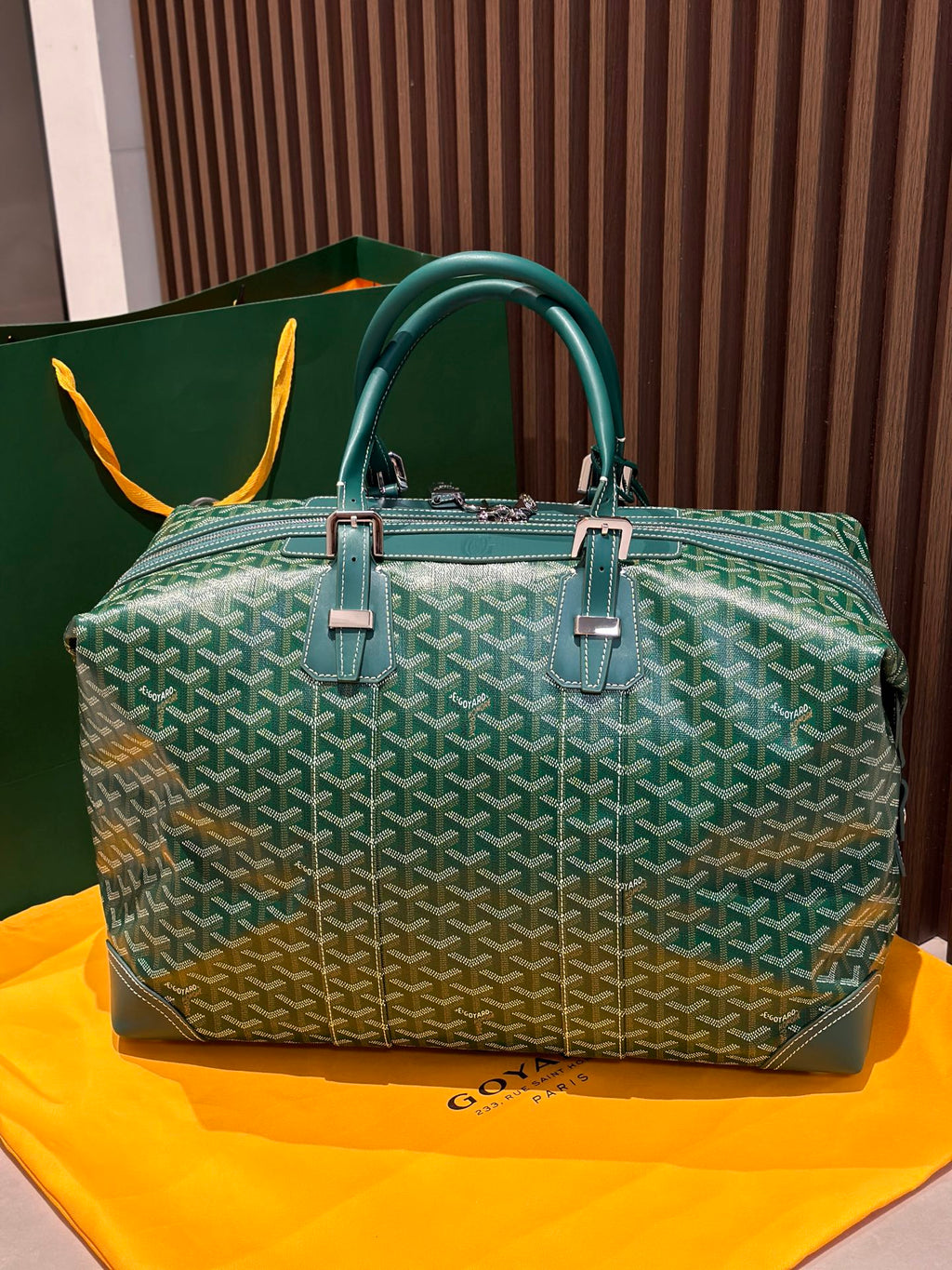 Green patterned duffel bag with top handles and structured front panel