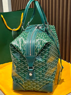 Green patterned duffel bag with top handles, front flap, and crossbody strap
