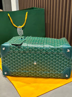 Green patterned duffel bag with front flap, studs, and top handles