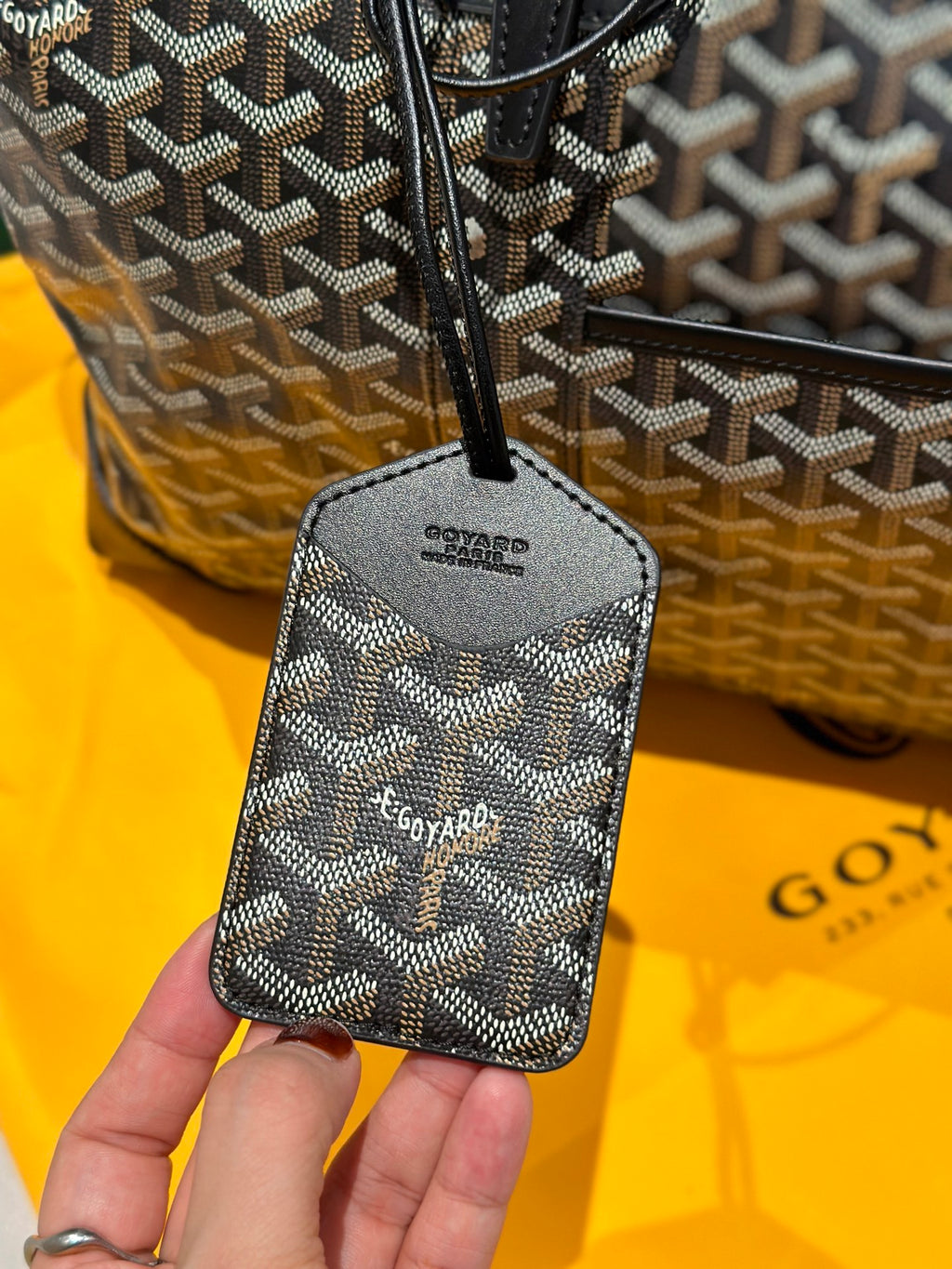 Goyard patterned vanity pouch with strap and zipper; dark base with logo pattern