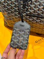 Goyard patterned vanity pouch with strap and zipper; dark base with logo pattern