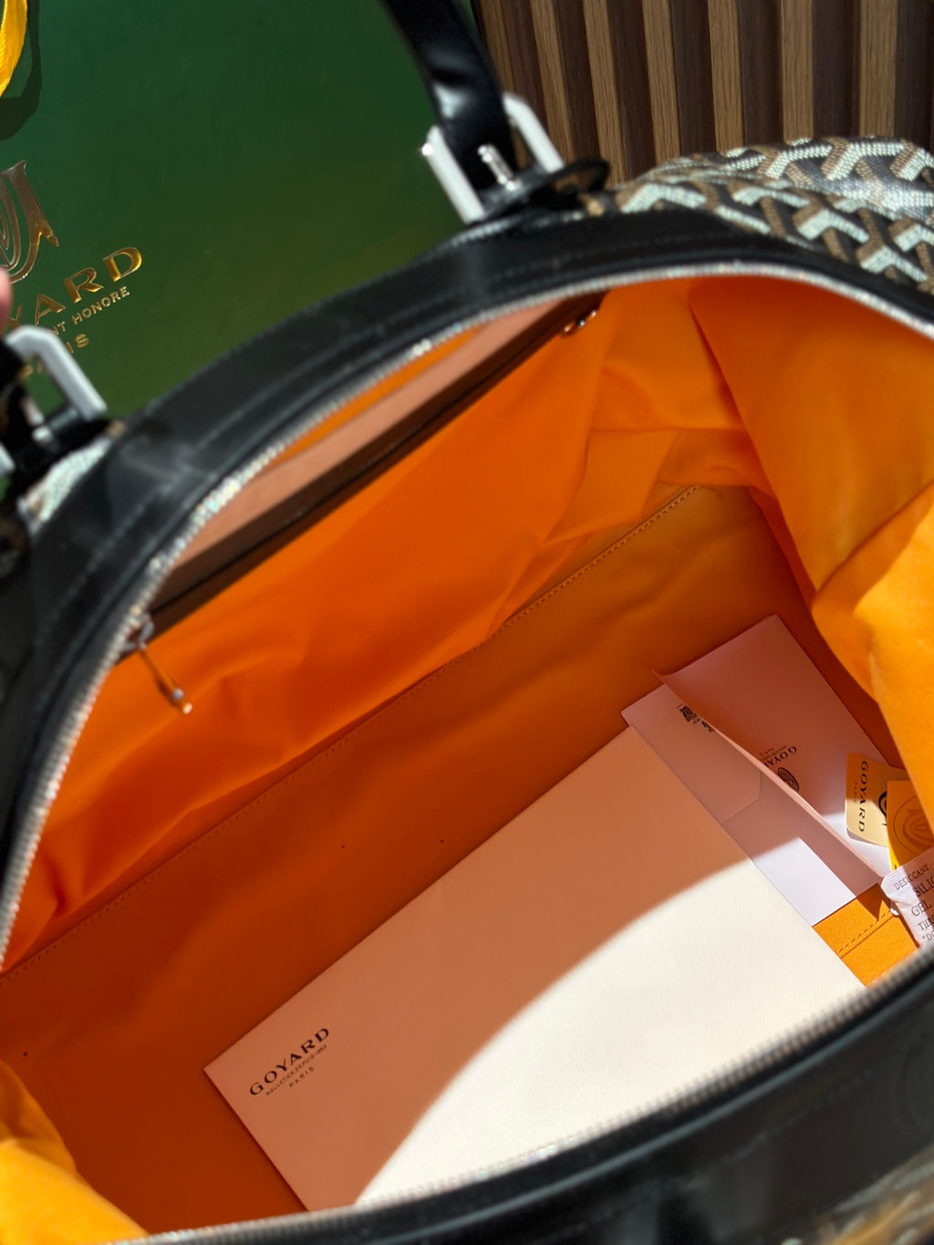 Goyard bag interior view with orange lining and inner zip pocket