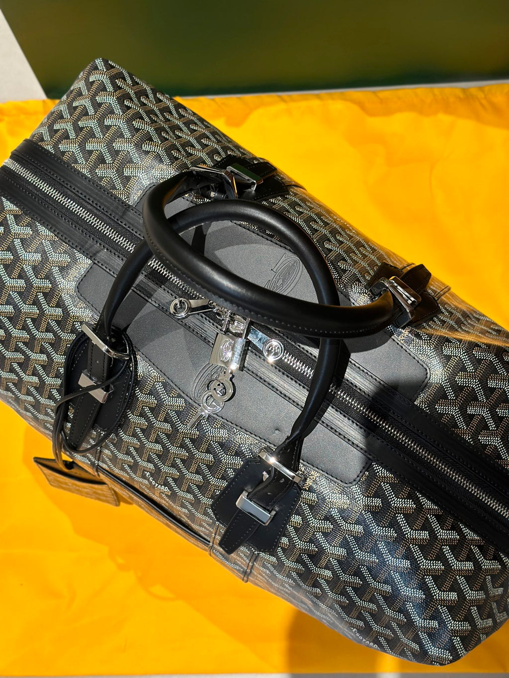 Goyard patterned duffel bag with top handles and side zip pocket, black trim