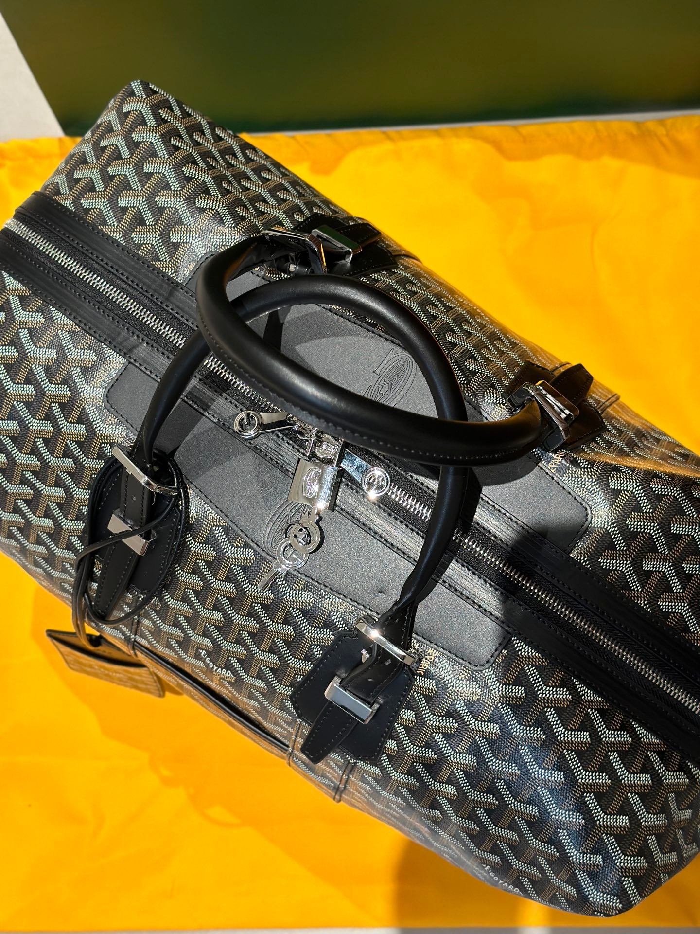 Goyard patterned duffel bag with top handles and side zip pocket, black trim