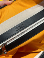 Goyard bag detail: black zipper with leather tab and embossed logo on lining