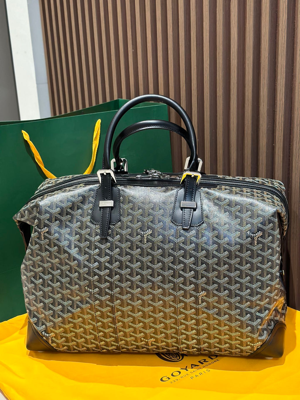 Goyard patterned travel bag with two top handles and front zip panel, black trim