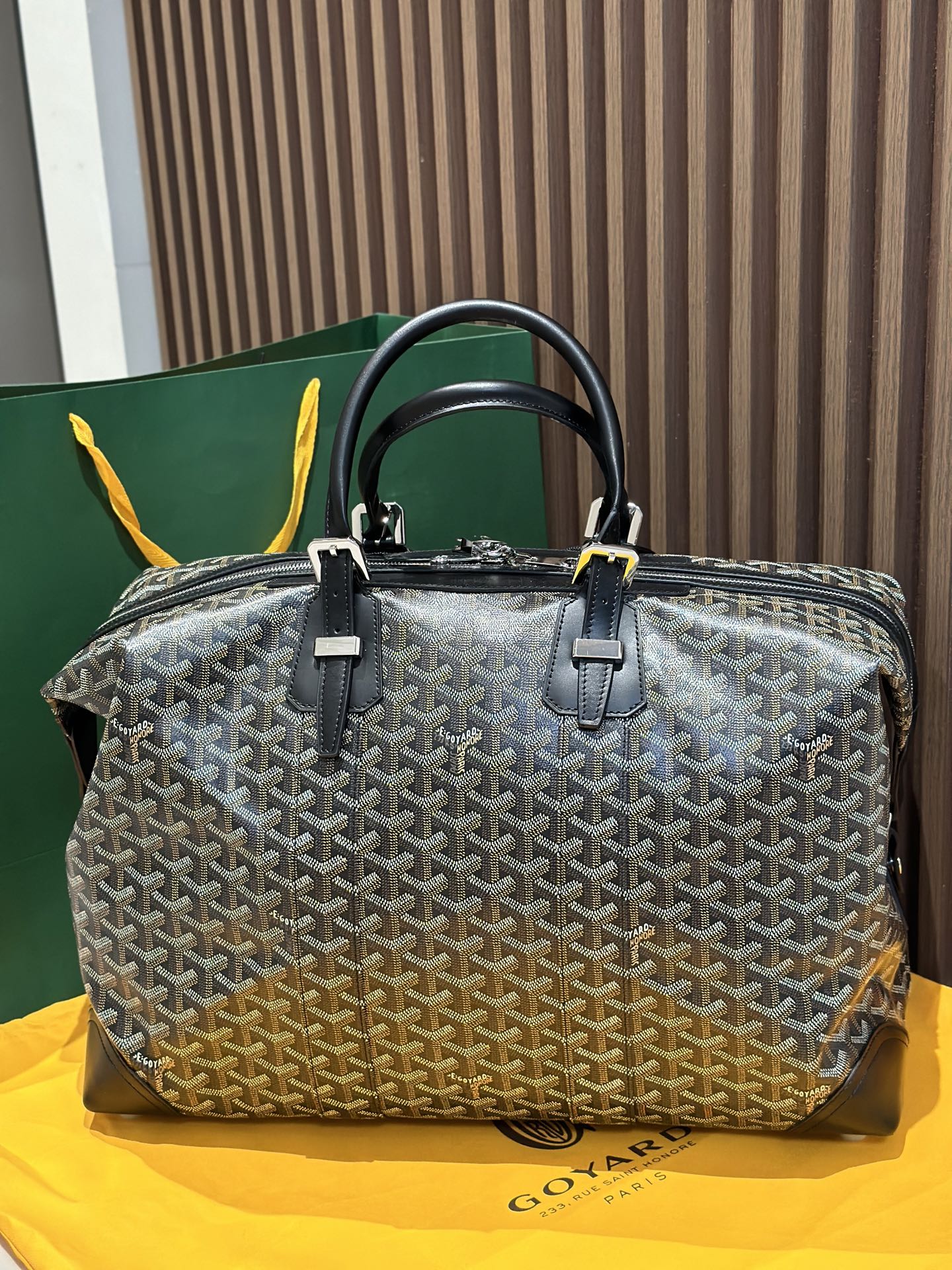 Goyard patterned travel bag with two top handles and front zip panel, black trim