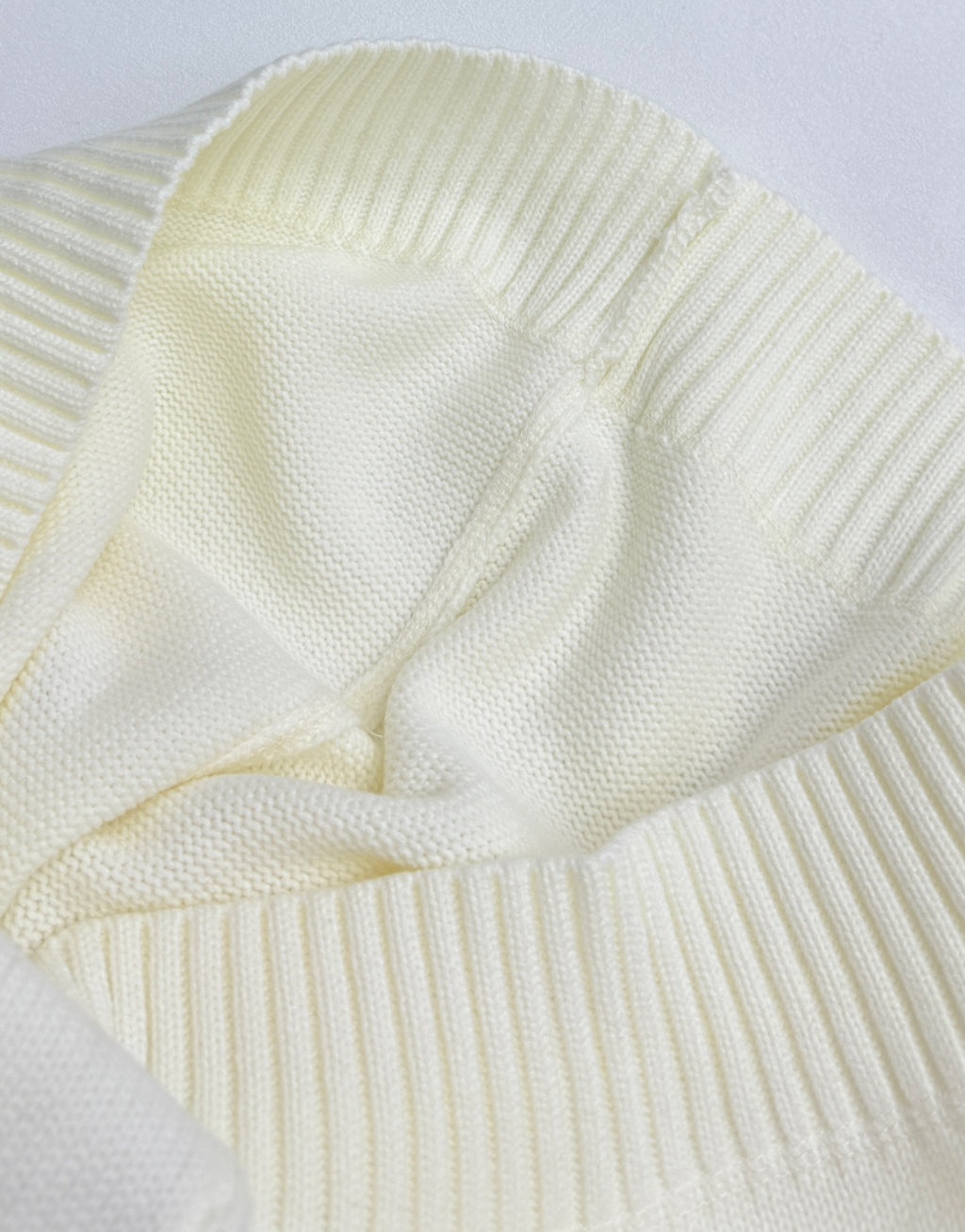 Knit sweater close-up of sleeves and stitched seam detail in pale yellow