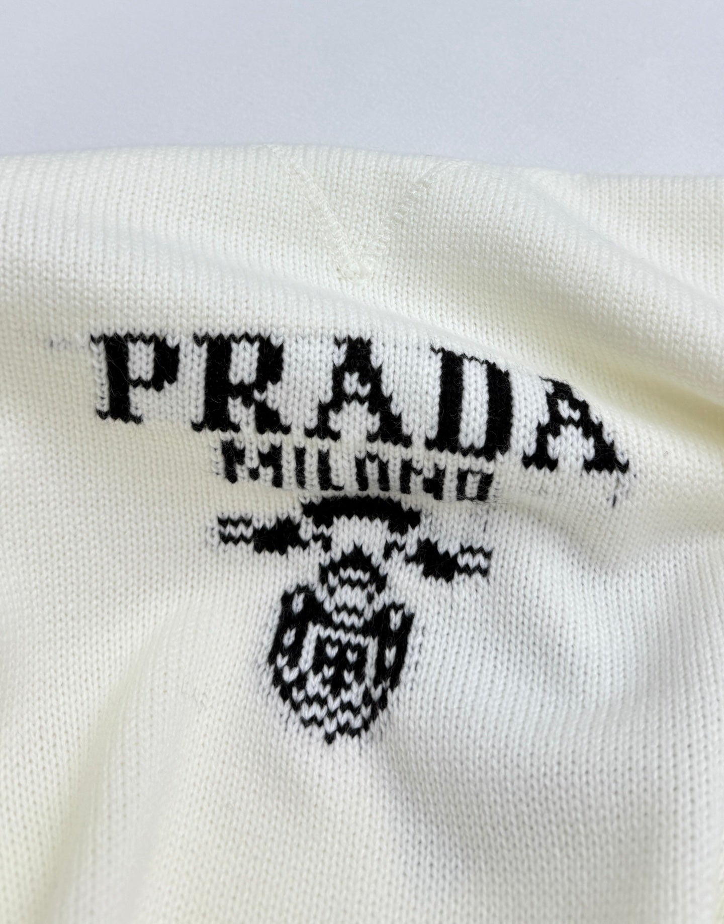 PRADA Milano logo graphic and crest on pale knit sweater front
