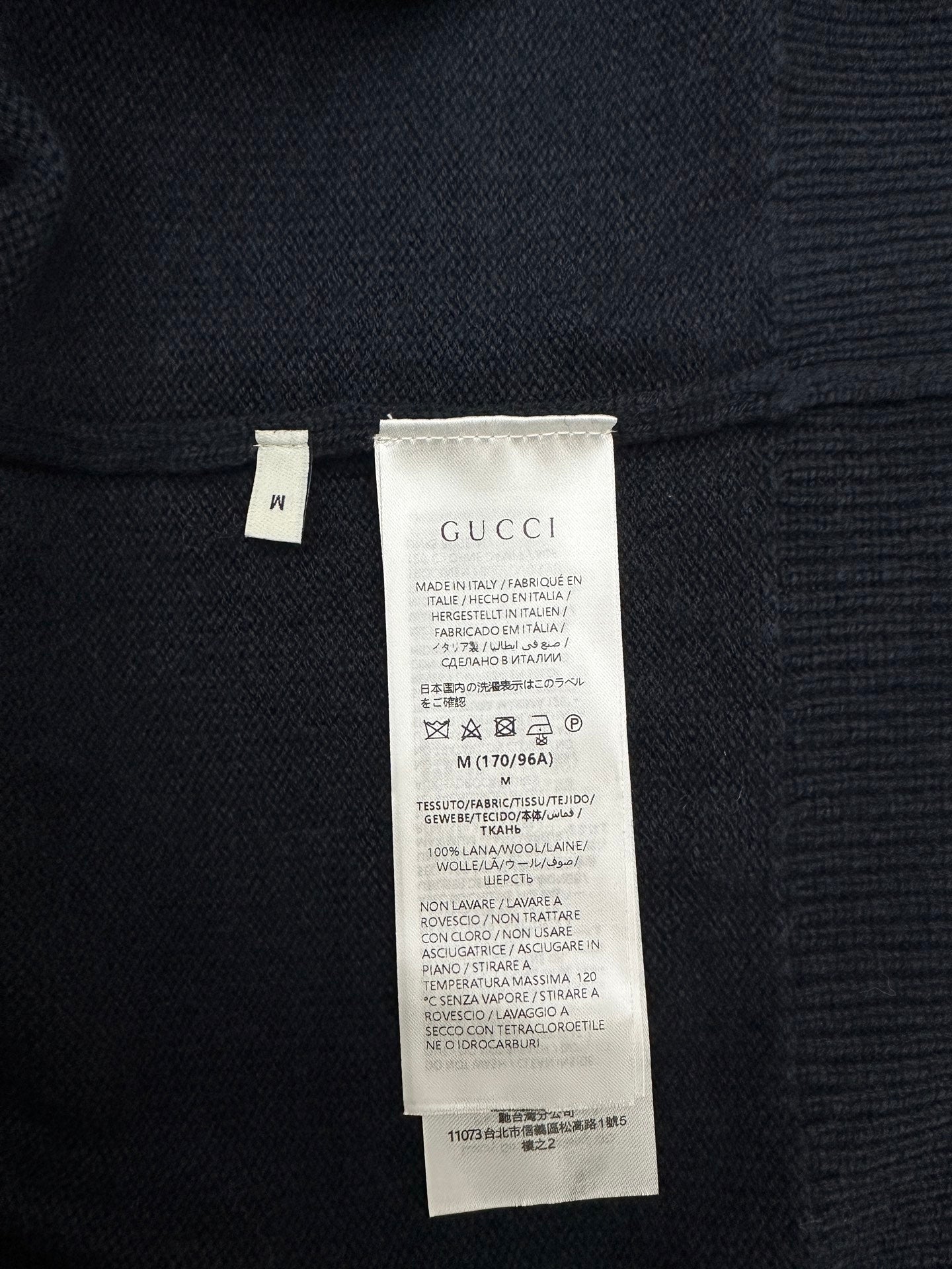 Black knit sweater with white care label at inner back