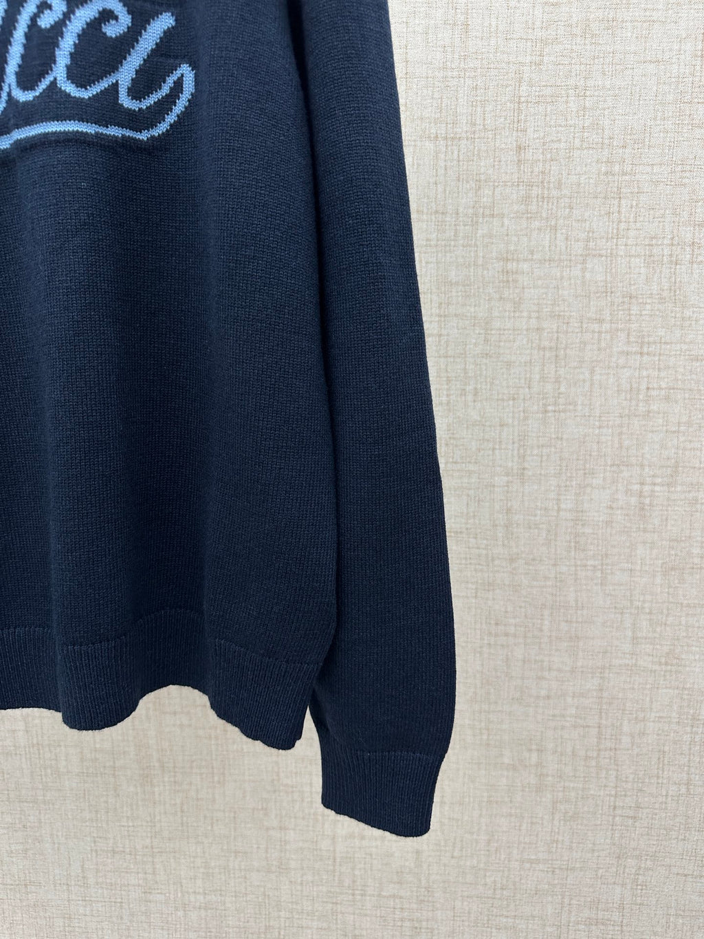 Navy knit sweater sleeve with ribbed cuff and curved hem