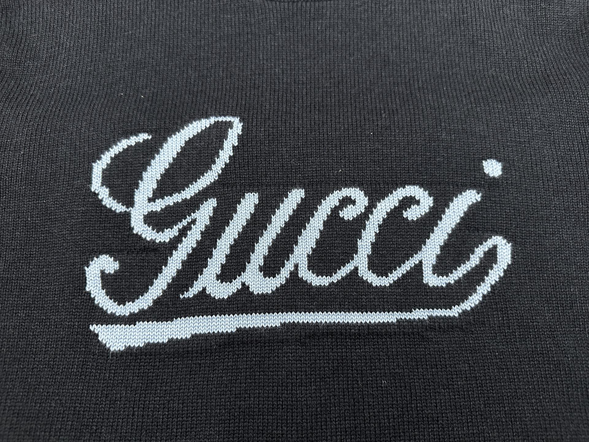 Navy knit sweater with large white 'Gucci' script embroidery