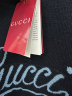 Black knit sweater fabric with red and white hanging brand tags
