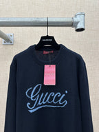 Navy knit sweater with large 'Gucci' script logo and hanging price tag