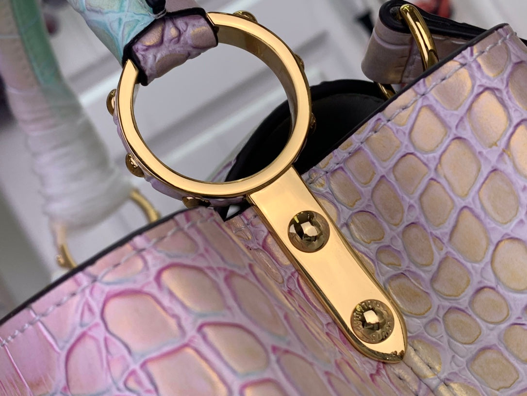 Louis Vuitton handbag detail: gold-tone D-ring and strap hardware on croc-textured pastel leather