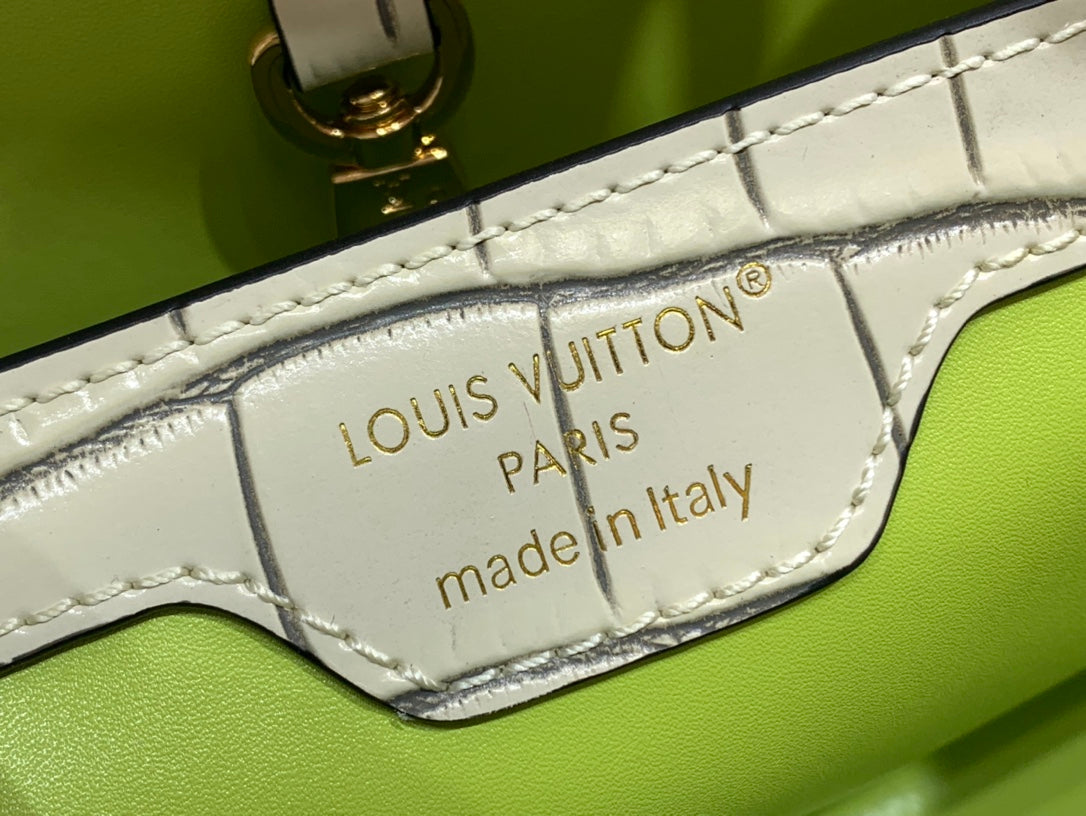 Interior leather label reading Louis Vuitton Paris, made in Italy on a light beige bag.