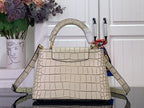 Light beige croc-embossed handbag with curved top handle and shoulder strap.