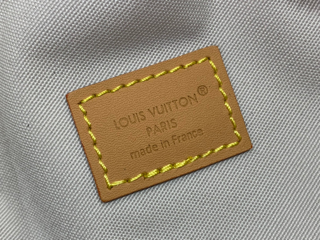 Tan leather logo patch reading Louis Vuitton Paris with yellow border stitching