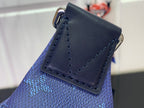 Blue fabric belt bag corner with dark leather patch and metal hardware ring