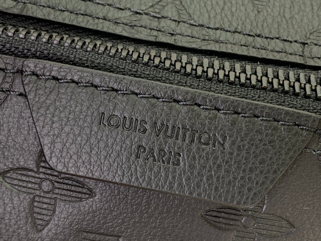 Leather logo stamp on dark zip pocket with stitching and “LOUIS VUITTON PARIS”