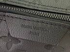 Leather logo stamp on dark zip pocket with stitching and “LOUIS VUITTON PARIS”